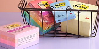 Un panier rempli de blocs-notes Post-it® colorés, présentant différentes tailles et formats de paquets
