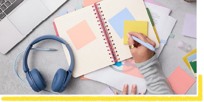 Un étudiant prenant des notes sur une note Post-it® jaune
